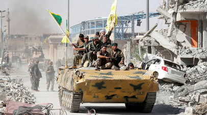 Бойцы курдских отрядов СДС въезжают в Ракку на бронетранспортёре