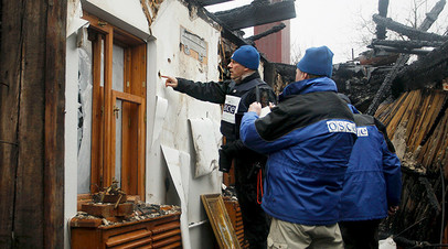 Сотрудники миссии ОБСЕ проводят осмотр разрушенного при обстреле жилого дома в Донецке 