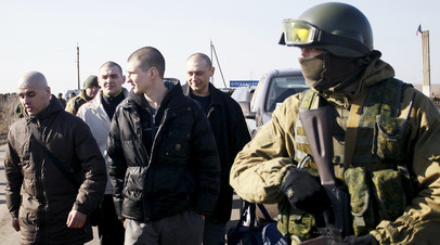 Военнослужащие ДНР охраняют украинских военнопленных во время процедуры обмена в районе населённого пункта Александровка