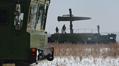 Военнослужащие ВС РФ контролируют загрузку ракеты на самоходную пусковую установку оперативно-тактического ракетного комплекса «Искандер-М»