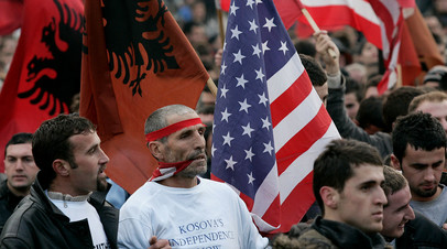 Албанцы во время протеста с американскими и албанскими флагами в столице Косово, Приштине