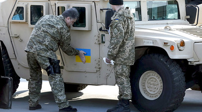 Президент Украины Пётр Порошенко приклеивает флаг страны к бронеавтомобилям Humvee, полученным из США в 2015 году