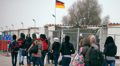Беженцы из Эритреи прибывают в лагерь временного размещения под Мюнхеном