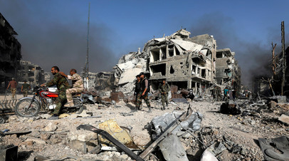 Солдаты сирийской армии среди руин города Эль-Хаджар-эль-Асвад, Сирия