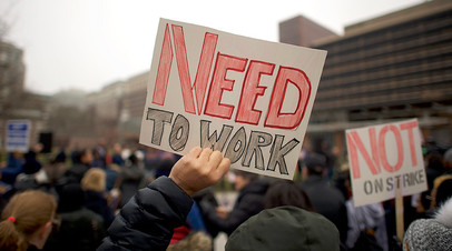 Демонстрация служащих федерального правительства находящихся в вынужденном отпуске. Надпись на плакате «Мне нужно работать». 