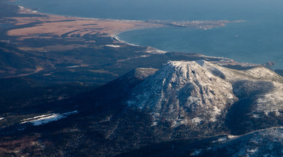 Вид на вулкан Менделеева и посёлок Южно-Курильск на острове Кунашир
