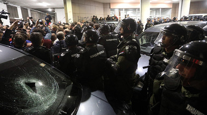 Полицейские и протестующие возле здания телерадиокомпании RTS в Белграде