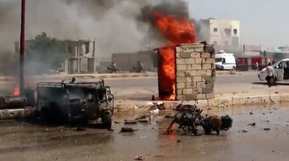 Сгоревший автомобиль и мотоцикл на дороге в Саракибе, Сирия 