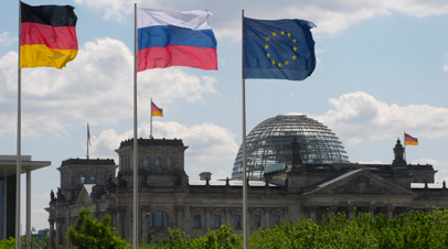 Флаги Германии, России и ЕС (слева направо) на фоне Рейхстага