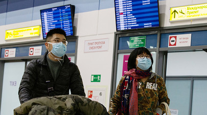 Пассажиры в защитных масках в зоне международных прилётов аэропорта Владивостока