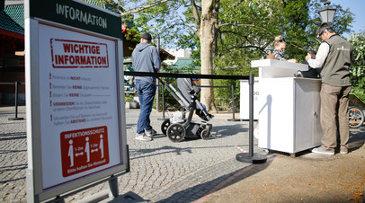 Посетители у входа в открывшийся берлинский зоопарк, в котором установлены правила социального дистанцирования