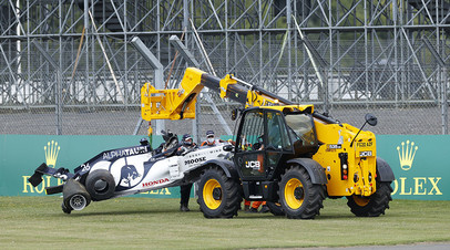 The car of AlphaTauri's Daniil Kvyat is lifted away after he crashed out of the race