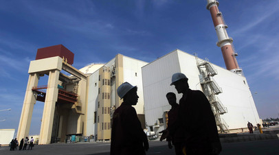 Иранские рабочие стоят перед Бушерской АЭС