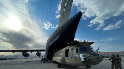 Вертолёт CH-47 Chinook загружен в транспортный самолёт C-17 Globemaster III ВВС США в международном аэропорту Хамида Карзая в Кабуле, Афганистан