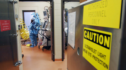 Архивное фото. Микробиолог надевает защитный костюм в НИИ инфекционных заболеваний в штате Мэриленд
