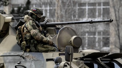 Военнослужащий на бронетранспортере БТР-82А ВС РФ на шоссе в районе границы с Украиной.