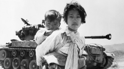 Корейская девочка с братом на фоне американского танка