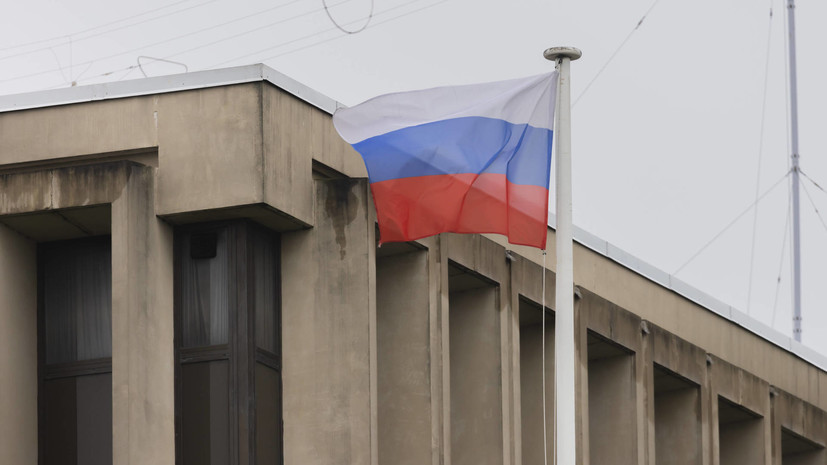 Люди несут цветы к стихийному мемориалу у посольства России во Франции