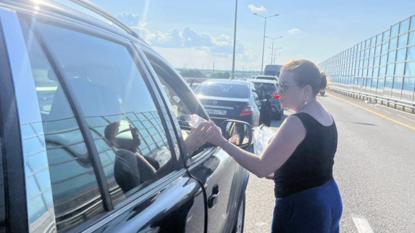 Волонтёры раздают воду в очереди к Крымскому мосту